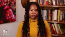 From video: Davis in yellow sweater in front of bookshelves and a painting, with "PBS NEWSHOUR," "#PBSNEWS," and the logo in the bottom left corner 