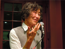 Berssenbrugge speaking into microphone at the Kelly Writers House