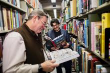 Adjunct Professor Robert Berry, left, and Assistant Professor of English Jean-Christophe Cloutier, who teach the undergraduate course Making Comics, enjoy two comics that are part of Van Pelt-Dietrich's collection, available to students, faculty, and staff.