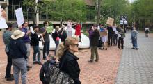 Supporters rally with signs around the Button on Locust Walk as Chi-ming Yang speaks into megaphone