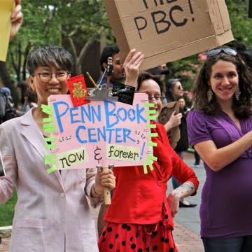Chi-ming Yang and other marchers hold signs in support of Penn Book Center at rally on Locust Walk