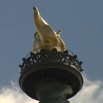 torch of Statue of Liberty in front of blue sky with white clouds