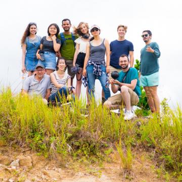 Team in casual clothing with equipment outside on hill with tall grasses. Front, from left, Penn professor Peter Decherney, camera operator Erica Liu, senior Arman Murphy. Back, from left: May graduate Vanita Flanagan, junior Ericka Lu, camera operator Enrique Unzueta-Miranda, junior Melisande McLaughlin, alumna Jean Lee, sophomore Alec Escobar, and local producer Armig Santos.