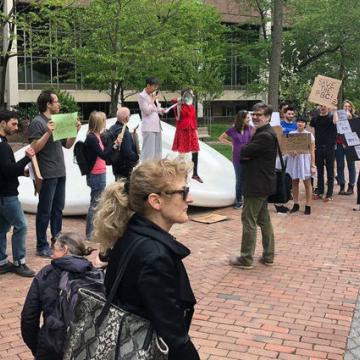 Supporters rally with signs around the Button on Locust Walk as Chi-ming Yang speaks into megaphone