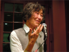 Berssenbrugge speaking into microphone at the Kelly Writers House
